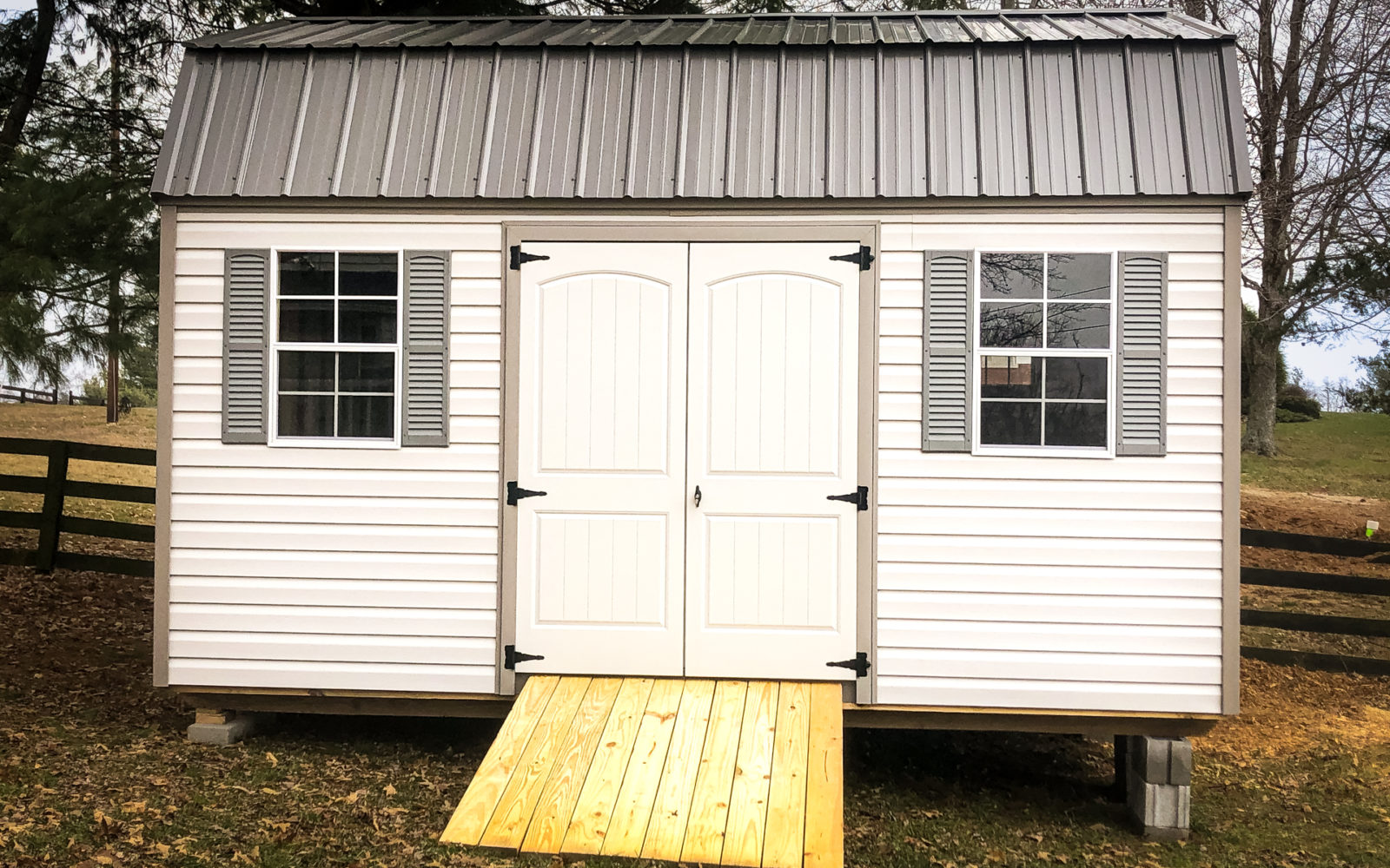 exterior of barn-style black roofed lawn mower storage shed