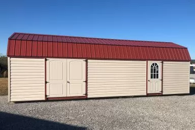 A lofted portable building in Kentucky with vinyl siding and a red metal roof