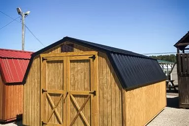 A portable building in Kentucky with wooden siding and a black metal roof