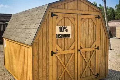 A discounted portable building in Tennessee with wood siding and a shingle roof