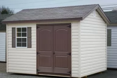 A shed in Kentucky with vinyl siding and brown double doors