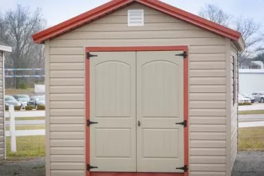 A shed in Kentucky with vinyl siding and a red metal roof