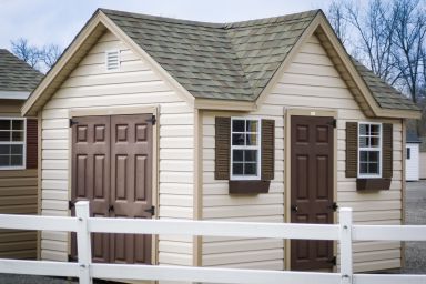 A shed in Kentucky with vinyl siding and a shingle roof with a dormer