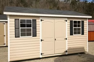 A vinyl shed with double doors, windows, and shutters