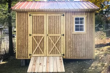 A wooden shed in Kentucky with double doors and a ramp