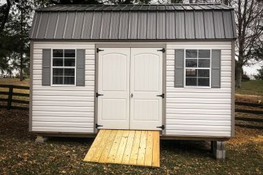 A lofted vinyl shed in Kentucky with double doors, windows, and shutters