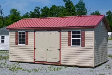 A vinyl shed in Tennessee with double doors, windows, and shutters