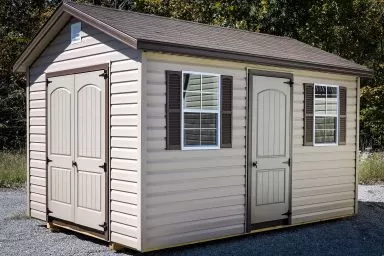 A brown vinyl shed in Tennessee with double doors, windows, and shutters
