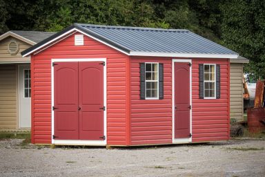 A shed in Tennessee with red vinyl siding and a metal roof