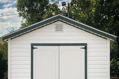 A shed in Tennessee with white vinyl siding and double doors
