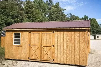 A shed in Tennessee with wooden siding, a window, and a metal roof