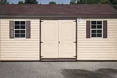 A discounted shed in Tennessee with vinyl siding, windows, and a double door