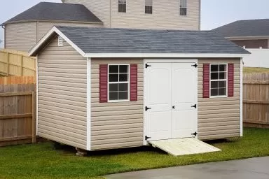 A shed in Tennessee with vinyl siding, double doors, and windows with shutters