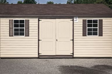 A discounted garden shed in Tennessee with vinyl siding, double doors, and a brown metal roof