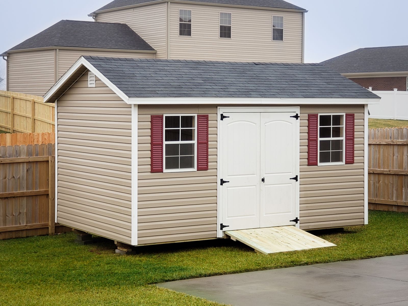 A garden shed in Tennessee with vinyl siding, double doors, and windows with shutters
