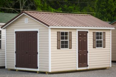 A storage shed in Kentucky with vinyl siding, double doors, and a brown metal roof