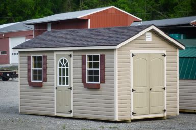 A storage shed in Tennessee with vinyl siding, double doors, and windows with flower boxes