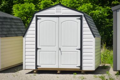 A backyard shed in Kentucky with white vinyl siding and double doors