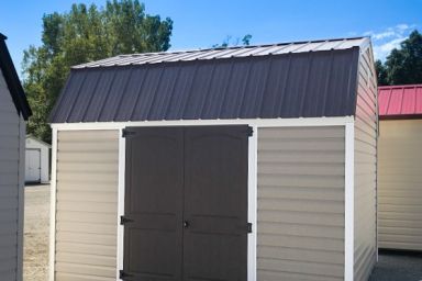 An outdoor shed in Tennessee with vinyl siding and a black metal roof