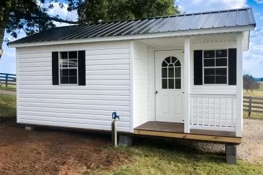 A prefab cabin in Kentucky with vinyl siding and a corner porch