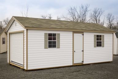 A portable garage in Kentucky with vinyl siding and a shingle roof