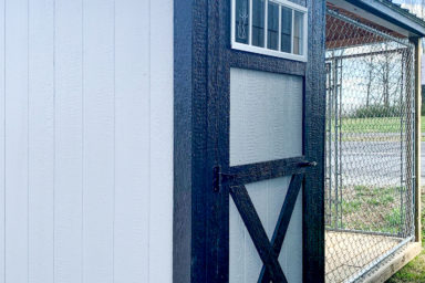 An outdoor dog kennel for sale in Tennessee with gray and black siding