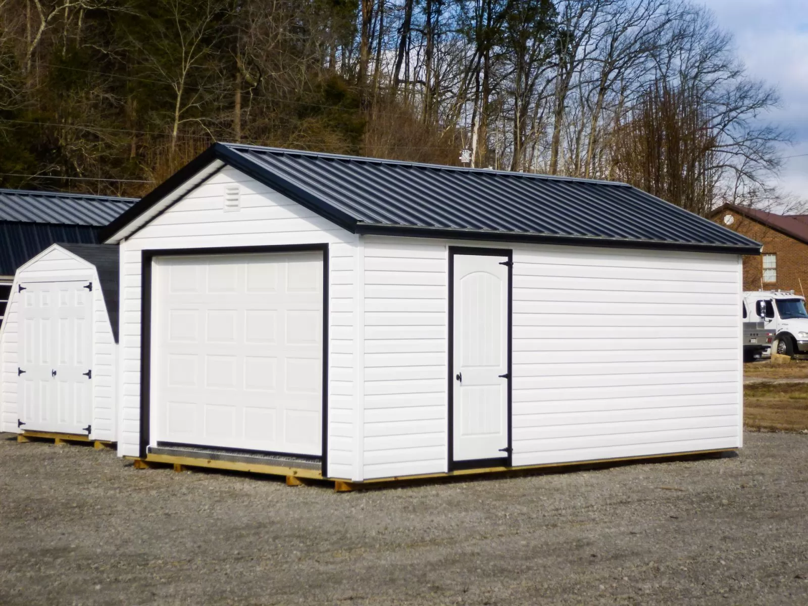 A garage shed in Kentucky with vinyl siding and a black metal roof