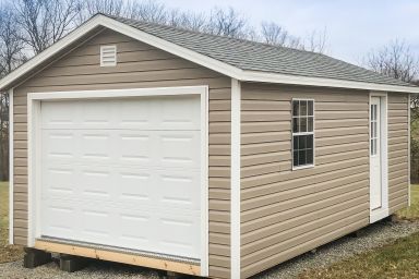 A garage shed in Tennessee with vinyl siding and a shingle roof